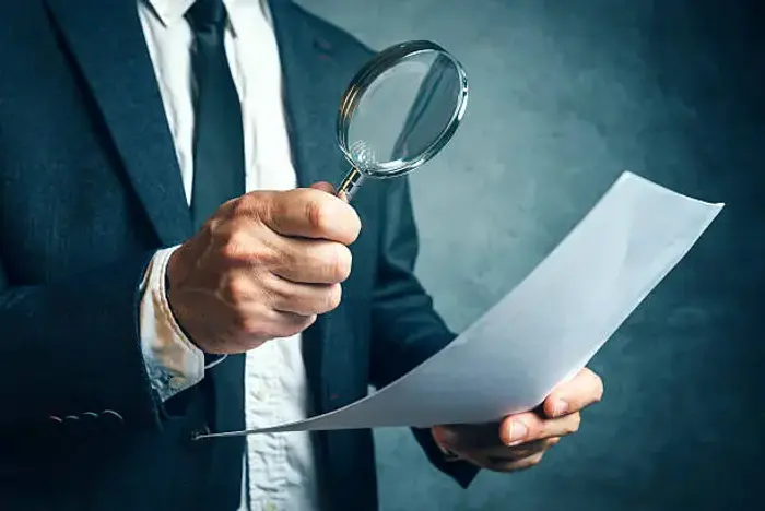 Magnifying glass reviewing a financial document